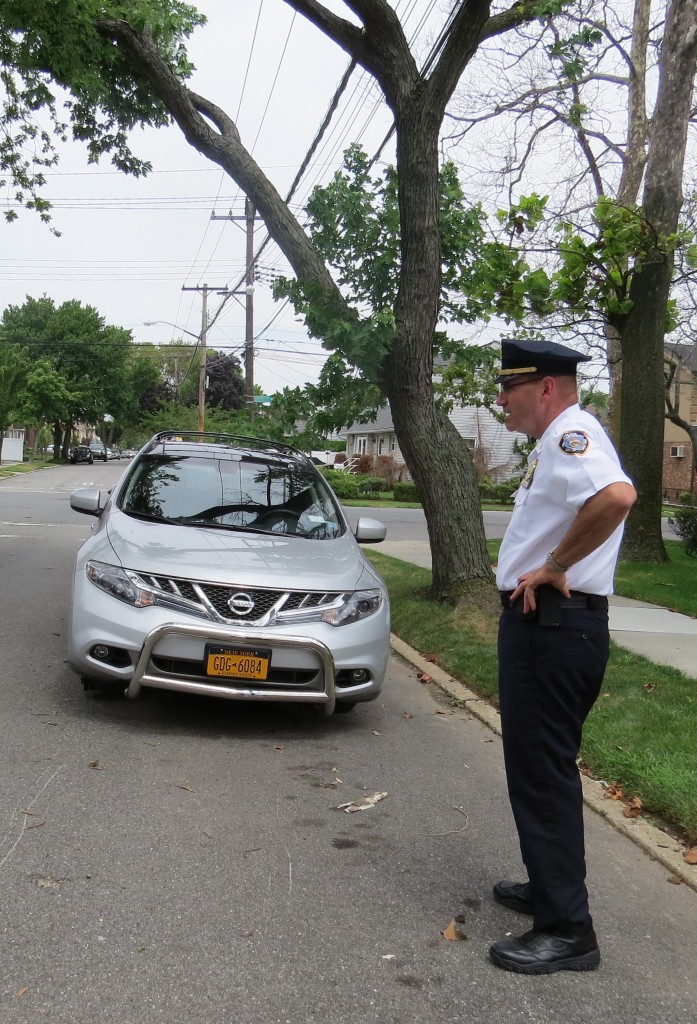 Hands on hips in frustration, Deputy Inspector Thomas Pascale stands in front of a 2012 Nissan Murano and looks across the street at a 2013 Honda Accord also stripped of its tires and rims. Patricia Adams/The Forum Newsgroup