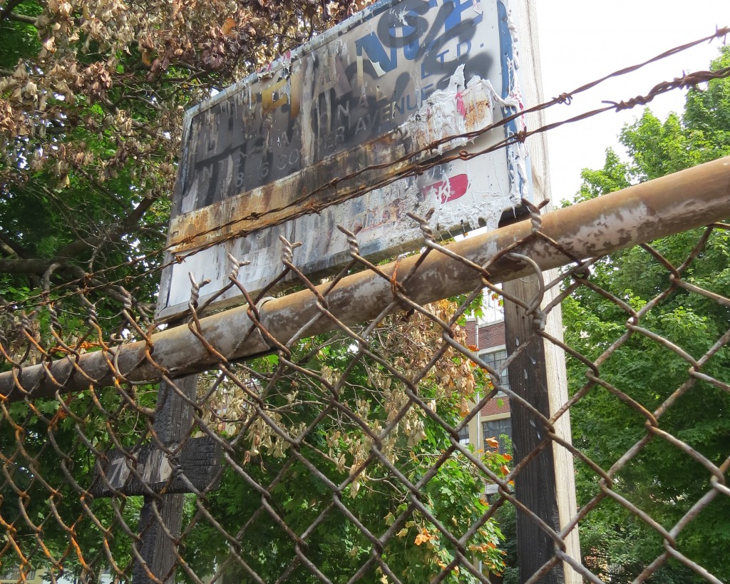 Graffiti now covers the sign for a factory that once operated at 78-16 Cooper Ave.