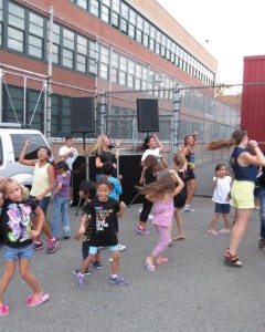 Children and adults have fun dancing as a dee-jay spins some music at PS 232.