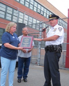 106th Precinct Community Council Vice President Donna Gilmartin, left, and President Frank Dardani, center, present a plaque of appreciation to Capt. Thomas Pascale, the commanding officer of the 106th.