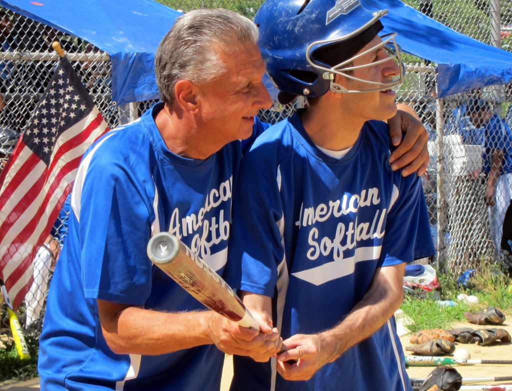 American Softball League founder Randy Novick, of Howard Beach, helps one of his players to bat at the group's last game of the season on Saturday. Hannah Sheehan/The Forum Newsgroup