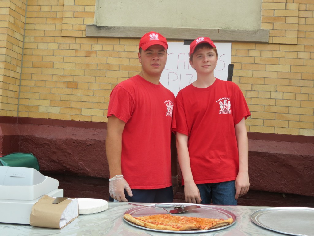 Anthony Caruana, left, and Robert Mikol, from the Original Carlo's Pizza, which has been in Middle Village since 1966, handed out slices during the festivities.