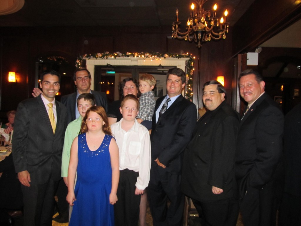 Paul Rudolph, third from right, who owns the Walker Funeral Home, was named as the Woodhaven Residents' Block Association's Man of the Year at the group's annual dinner fundraiser last week. Rudolph was joined by his wife and children, as well as Councilman Eric Ulrich, left, state Sen. Michael Gianaris, second from left in the back, state Assemblyman Mike Miller, second from right, and state Sen. Joe Addabbo Jr., right. Photo Courtesy Josephine Wendell