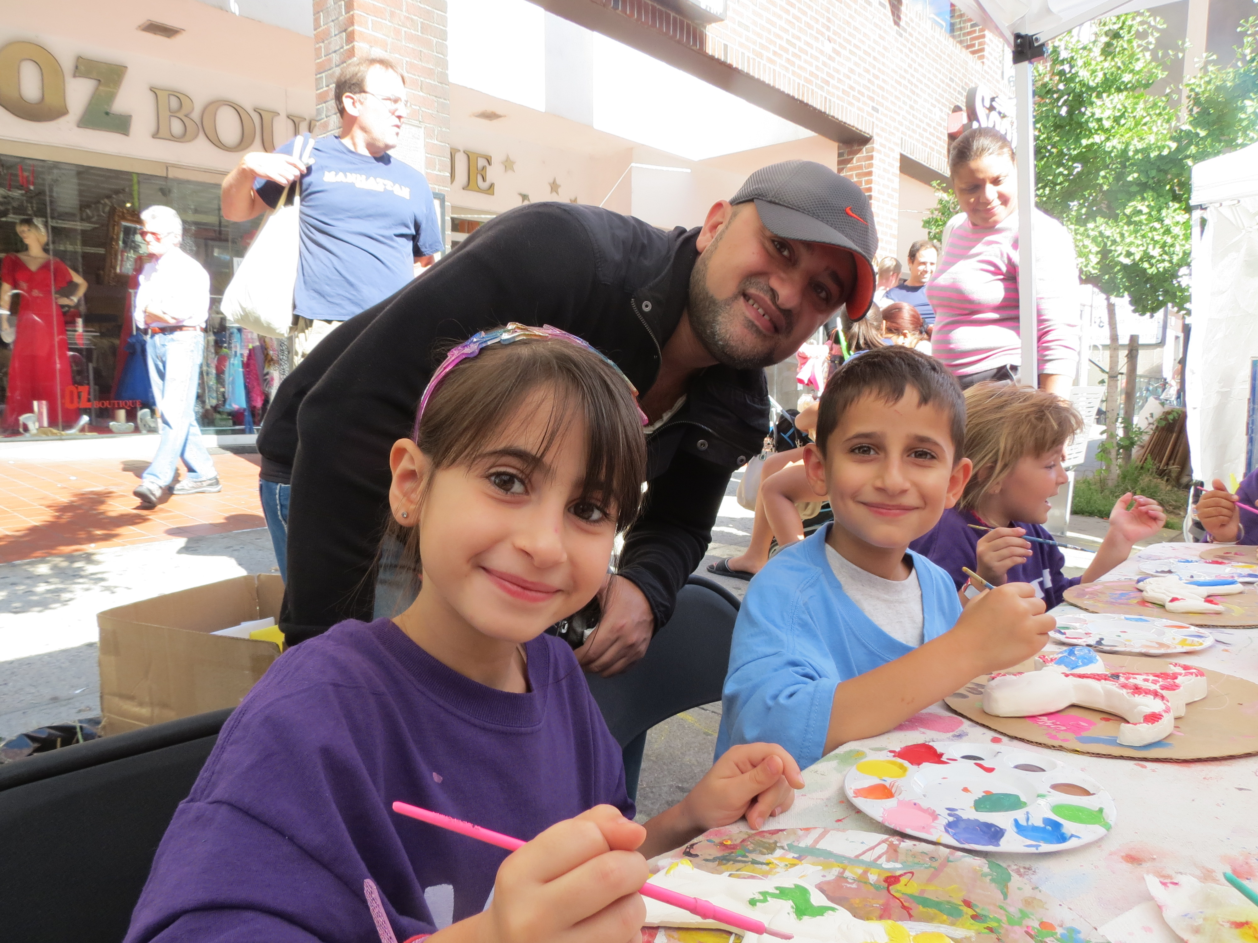 Liel Kalen, 7, left, her father Steven, and brother Stav, 8, of Forest Hills, paint in the booth from the business Plaster Fun.