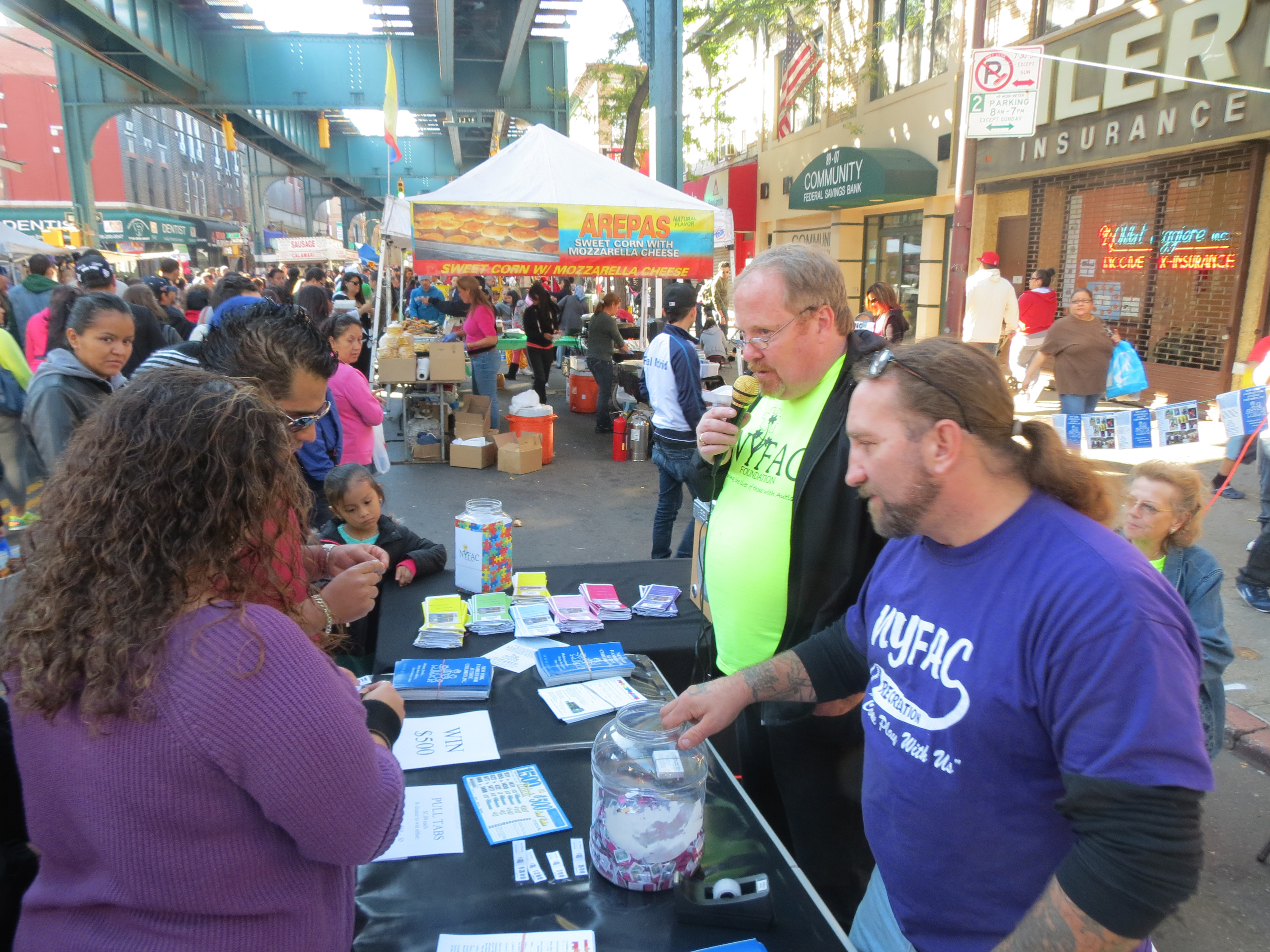 Mike Brothers, left, and Frank Scafo, of the New York Families for Autistic Children, talk to residents about their organization. NYFAC works with children with autism and their families from throughout Queens - and beyond. NYFAC board of directors members also held a raffle at their booth to help raise money for the nonprofit, and the winner landed a $500 prize.