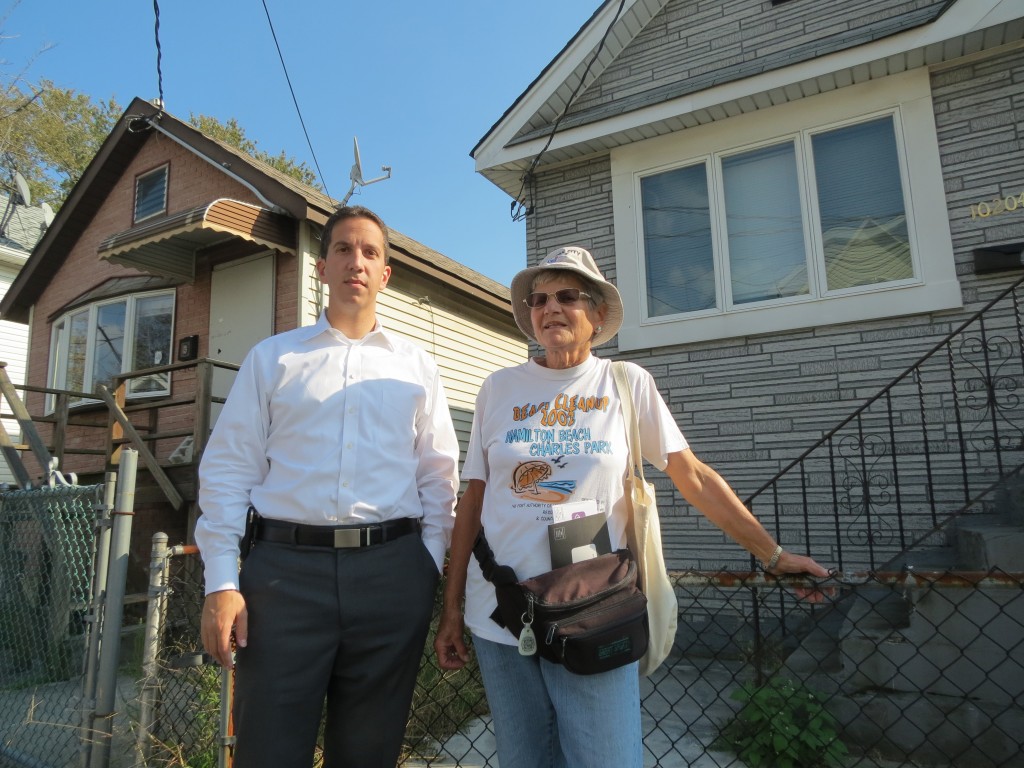 Assemblyman Phil Goldfeder and civic leader Marie Persans stand in front of two abandoned homes on 163rd Road in Hamilton Beach. Anna Gustafson/The Forum Newsgroup