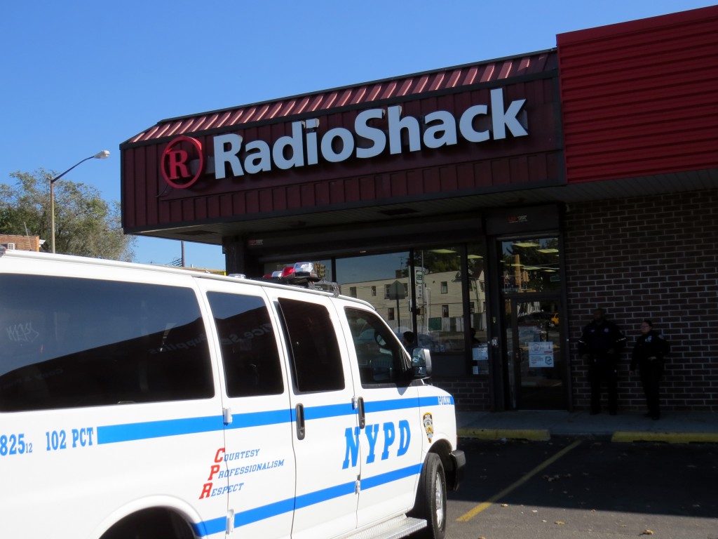 Police stand guard outside the Radio Shack location on Atlantic Avenue at 107th Street while investigators combed the store for possible evidence to identify the gunmen. Robert Stridiron/The Forum Newsgroup