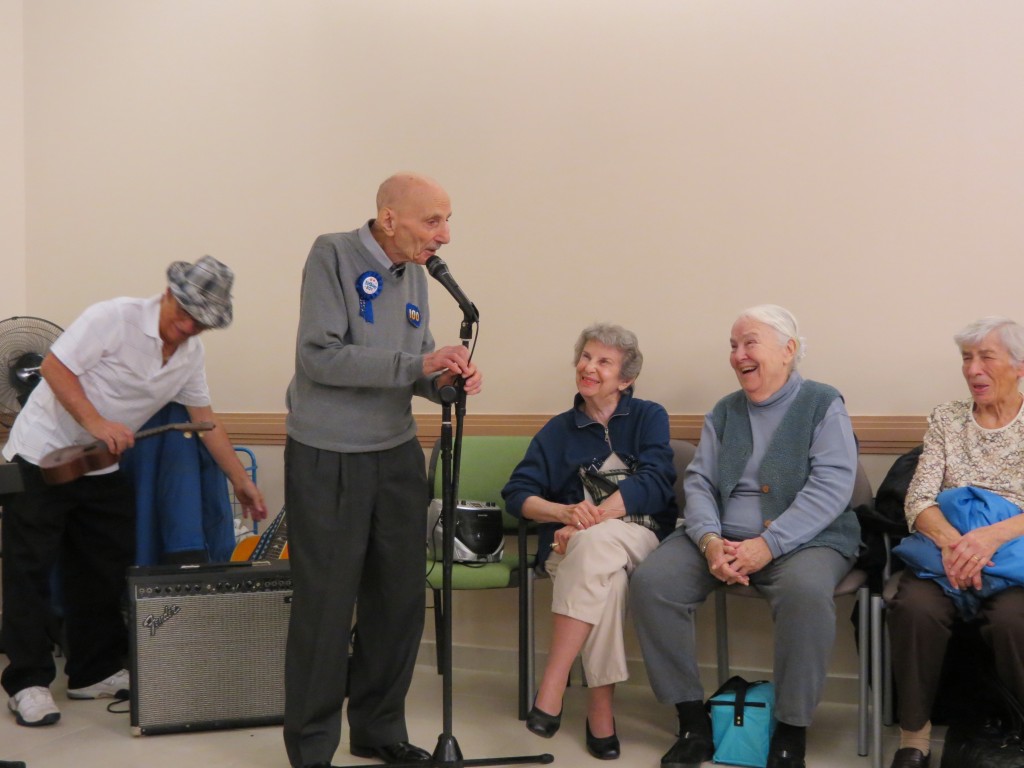 Max Stern makes the crowd of friends and family gathered to celebrate his 100th birthday erupt into laughter at the Howard Beach Senior Center. Anna Gustafson/The Forum Newsgroup 