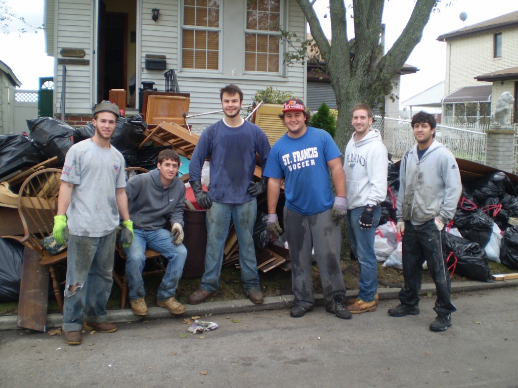 After my family’s home on 160th Avenue was flooded by the surge from Hurricane Sandy, our son David organized five classmates who graduated with him from St. Francis Prep in 2008 to help with the clean-up.  Standing in front of the rubble of our house are (l. to r.): Tommy Garofola, Larry Mongelli, Joe Iemma, David Marino, Chris Costello, and Michael Biordi. –Steve Marino  Photo Courtesy Steve Marino  