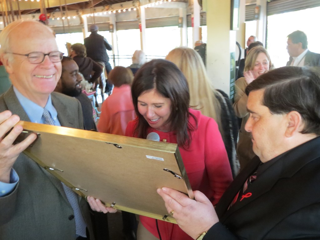 City Landmarks Preservation Commission Robert Tierney, left, Councilwoman Elizabeth Crowley, and Assemblyman Mike Miller admire a City Council proclamation thanking Tierney for his support for the carousel.
