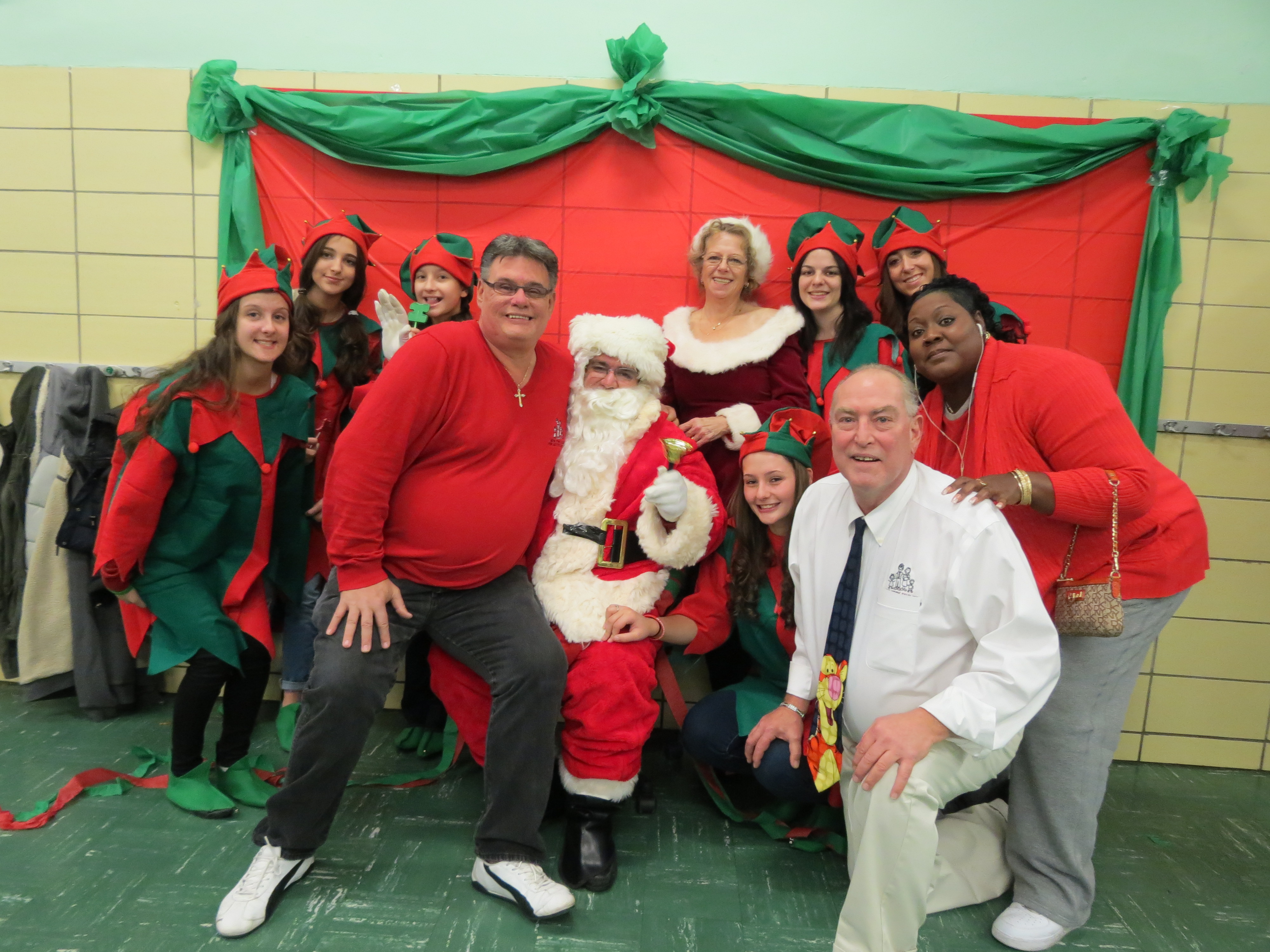 NYFAC President Andrew Baumann, front left, NYFAC Program Director Leo Compton, front right, and other revelers ring in the holiday season with Santa.