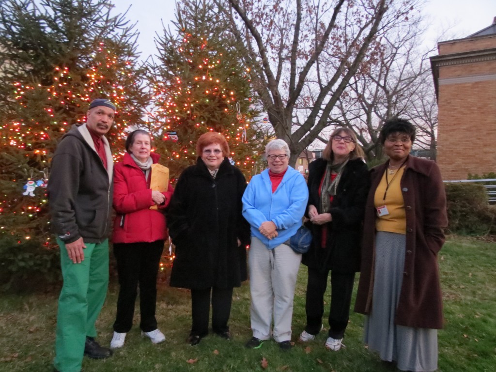 Friends of the Richmond Hill Library board members, Councilwoman Karen Koslowitz, and Rebecca Alibatya, manager of the Richmond Hill Library, celebrated the library's annual Christmas tree lighting outside the historic building at 118-04 Hillside Ave. Monday evening. Anna Gustafson/The Forum Newsgroup 