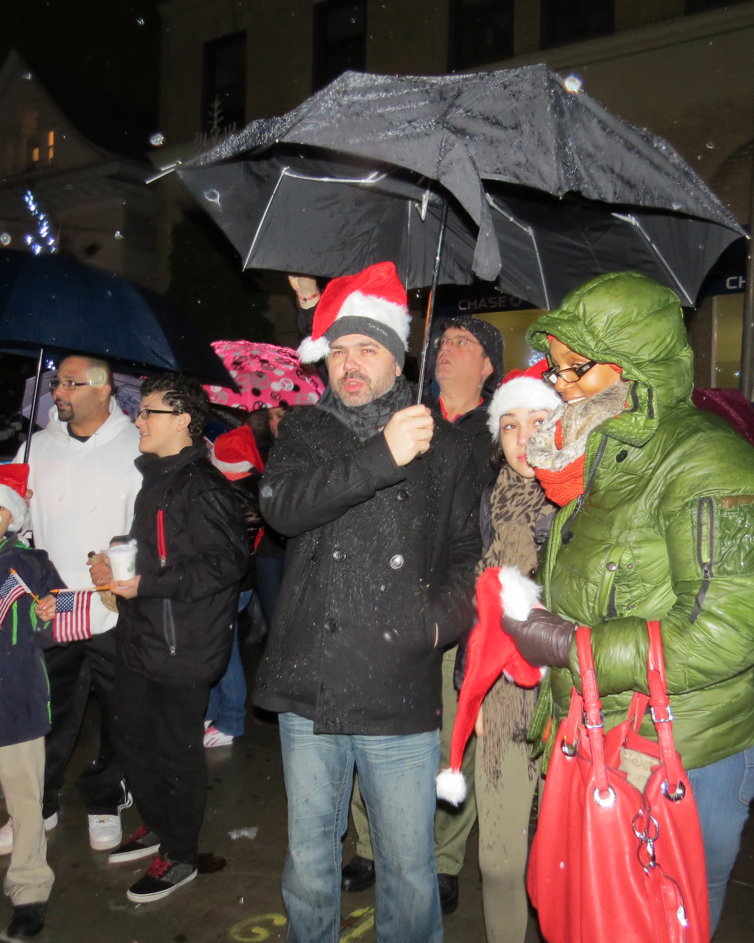 Rain wasn’t enough to dampen the spirits of families who crowded under umbrellas waiting for the countdown to light the tree.