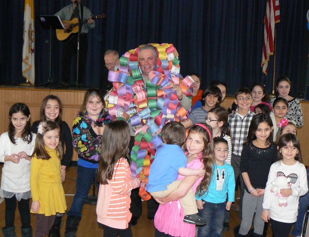  Deacon Alex Breviario, center, surrounded by the giant paper chain presented to him by parish children.  Photos courtesy Our Lady of Grace