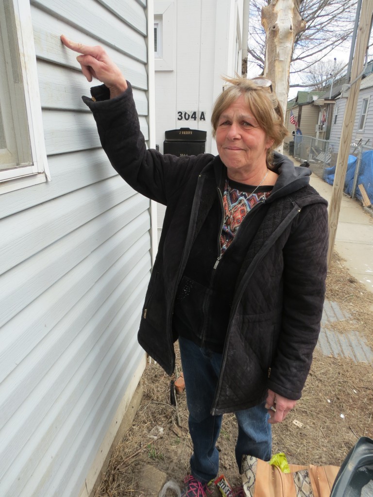 Patricia Andre, who has lived in Rockaway for about 50 years, points to where the water rose at the home where she and her family have lived for decades. Photos by Anna Gustafson