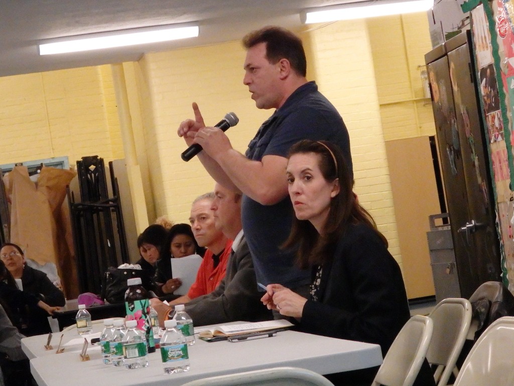 CEC 24 President Nick Comaianni, standing, addresses the crowd gathered at Monday night’s meeting.  Phil Corso