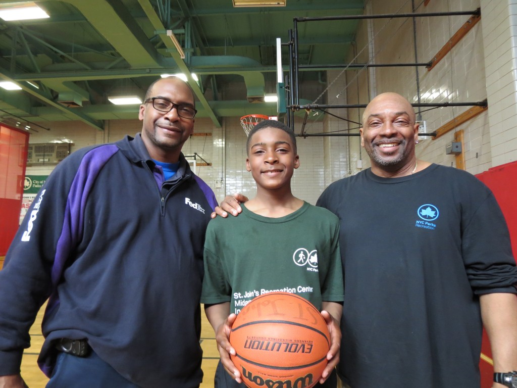Gerald Gittens, left, and Lloyd McCrorey, right,  the recreation director at St. John's, said the younger Gerald Gittens, center, is increasingly becoming a powerhouse on the basketball court and baseball field. Photos by Anna Gustafson