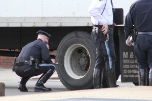 A policeman investigates the box truck that hit a pedestrian in Woodhaven last week.  Photo by Richard York 