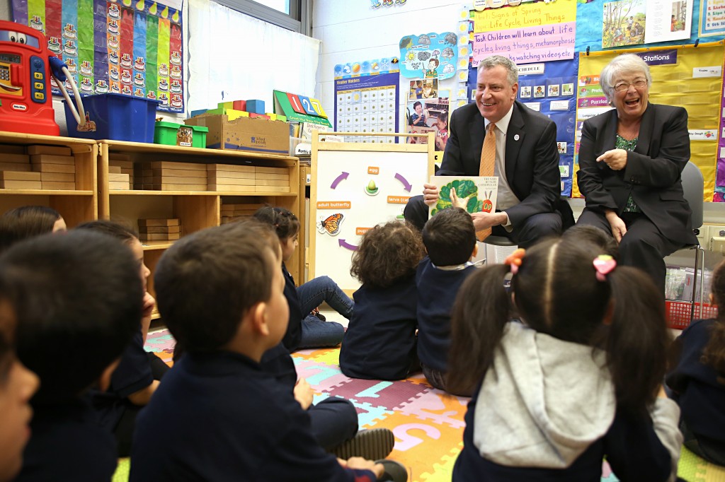 Mayor Bill de Blasio, center, and City Schools Chancellor Carmen Fariña, right of de Blasio, spend time with students at PS 239 in Ridgewood last week. Photo courtesy NYC Mayor's Office