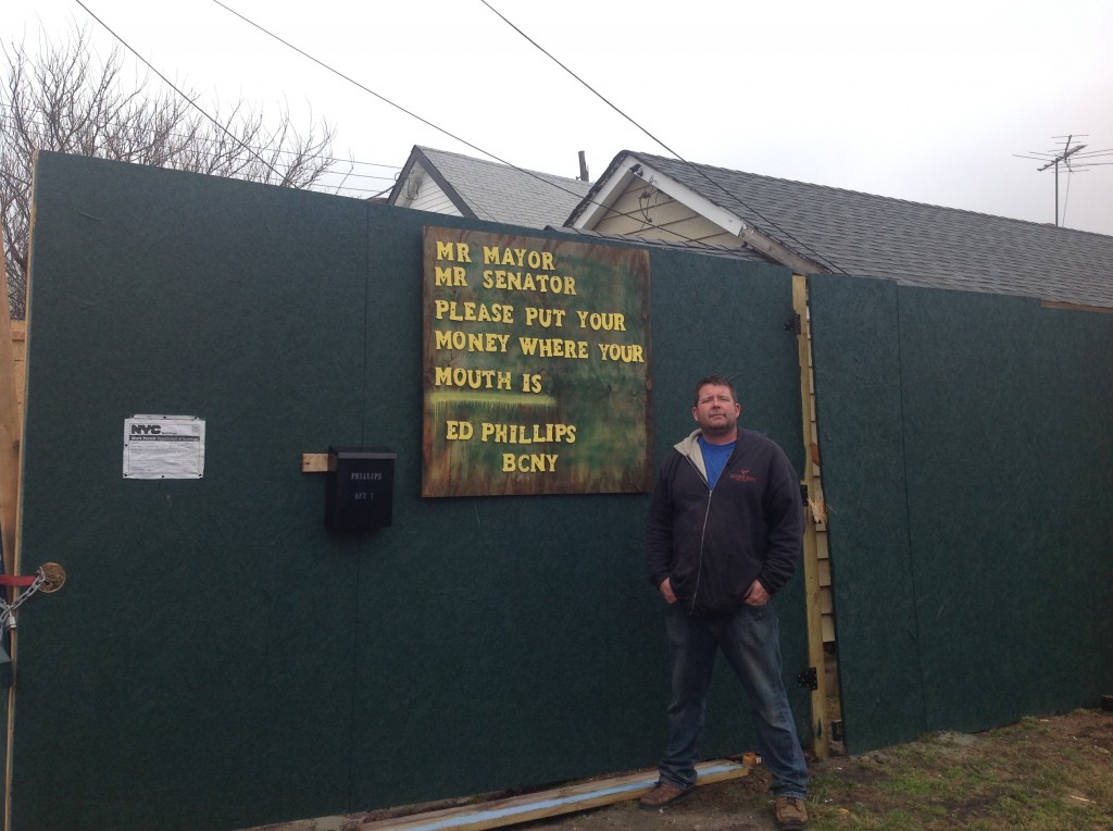  Ed Phillips stands in front of the site where his house once stood in Broad Channel. He and his family have been unable to move back into their home in part because they said they are being strangled by bureaucratic red tape from the city. Photo courtesy Ed Phillips