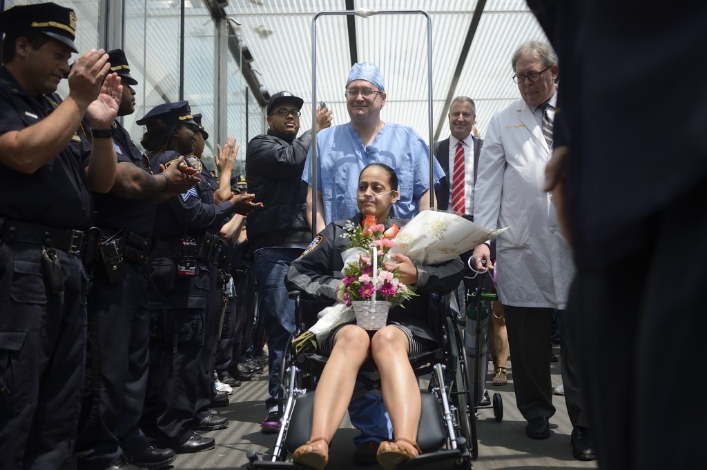 Police officers and elected officials, including Mayor Bill de Blasio, second from right, celebrate Police Officer Rosa Rodriguez's discharge from Weill Cornell Medical Center on Monday.  Photo courtesy Rob Bennett/Mayor's Office 