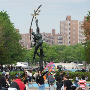 Residents take a break from Sunday's festivities to relax by the "Rocket Thrower," a massive bronze sculpture designed by Donald De Lue for the 1964 World's Fair. The work is in keeping with one of the central themes of that fair - space exploration.  Photo by Anna Gustafson
