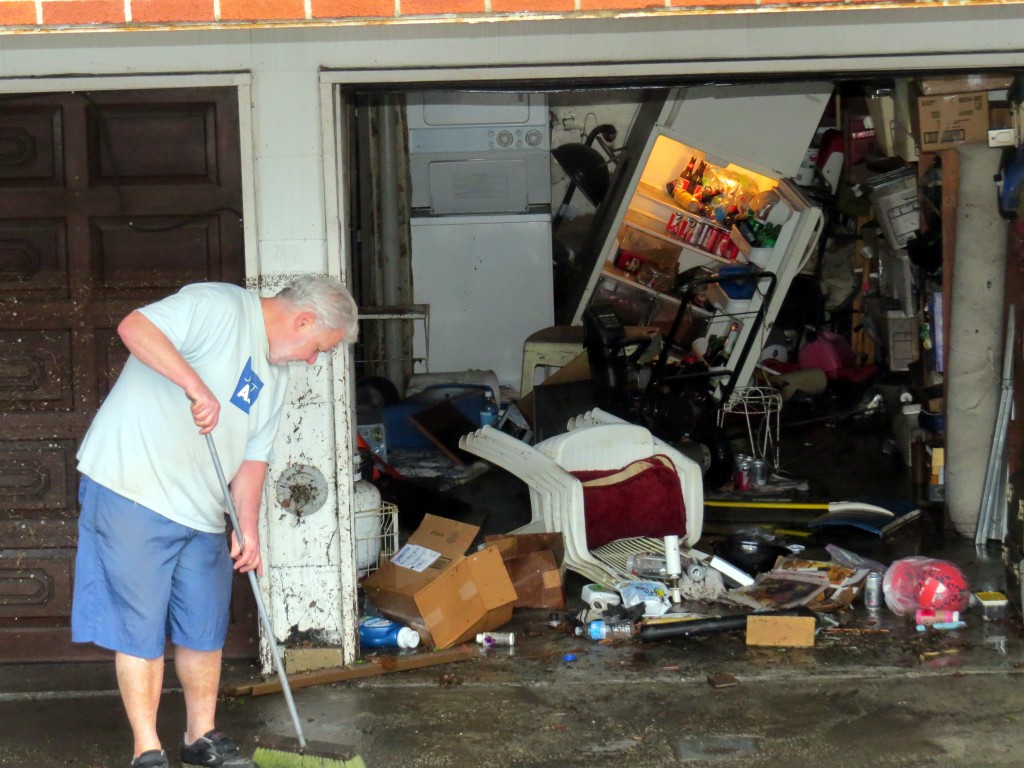 A Lindenwood resident cleans out his garage following Wednesday's massive rainstorm. Photo by Robert Stridiron