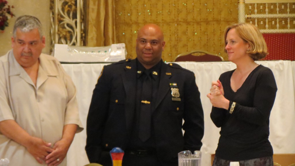 CB 9 Chairman Ralph Gonzalez, left, and Queens Borough President Melinda Katz, right, present a community recognition award to 102nd Community Affairs Officer Jose Severino at the board's meeting Tuesday night.  Photo by Anna Gustafson