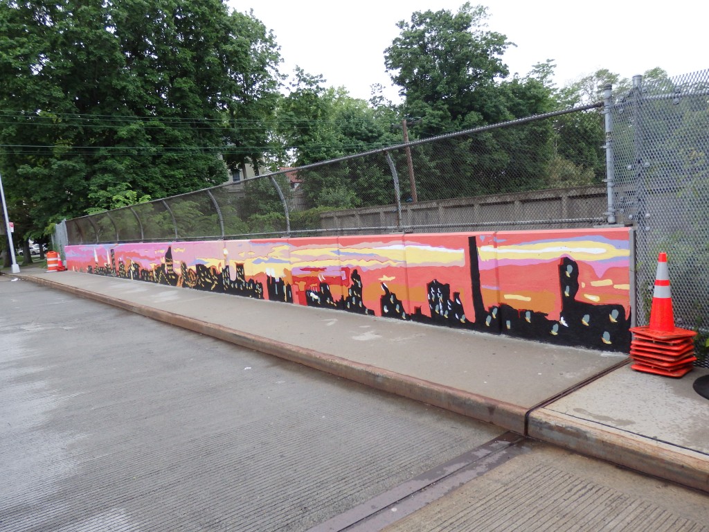 A Kew Gardens overpass now boasts a new mural, which is meant to show Kew Gardens as a transition point between the towering buildings of the city and the open air of Long Island.  Photo by Phil Corso