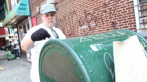 A Woodhaven volunteer paints over unsightly and unwanted graffiti on a mailbox to discourage further vandalism in the community.  Photos by Cesar Bustamante