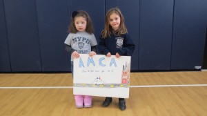 Amalia Ciccio (l.), of Mrs. Drucker's pre-k class, and Abigail Edmundson, of Miss Lucie's kindergarten class, showed their love and appreciation for the NYPD. Forum Photos by Michael V. Cusenza