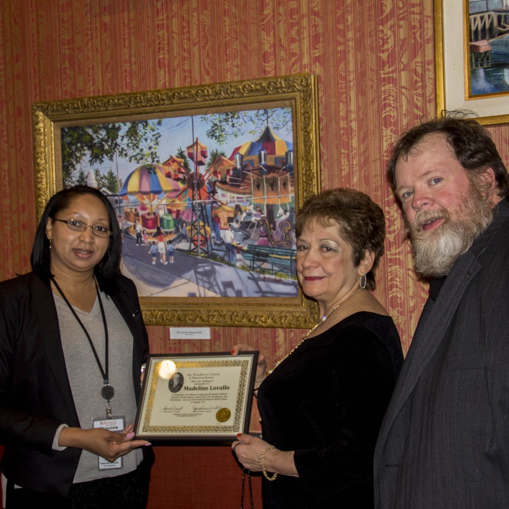 Artist Madeline Lovallo received an award from the Woodhaven Cultural & Historical Society and is joined here at the South Ozone Park casino by Michelle Stoddart, director of public relations at Resorts World NY, and Ed Wendell, president of the WCHS. Forum Photo by Alan Krawitz.