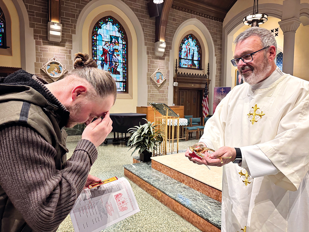 Photo Courtesy of Alexandra Moyen Deacon Kevin McCormack leads the faithful in the veneration of the relic of St. Carlo Acutis.